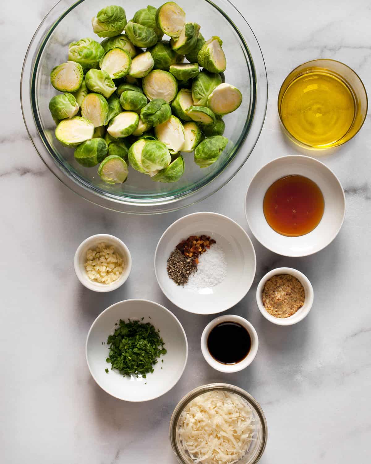 Ingredients including brussels sprouts, olive oil, mustard, honey, balsamic vinegar, parmesan and spices.