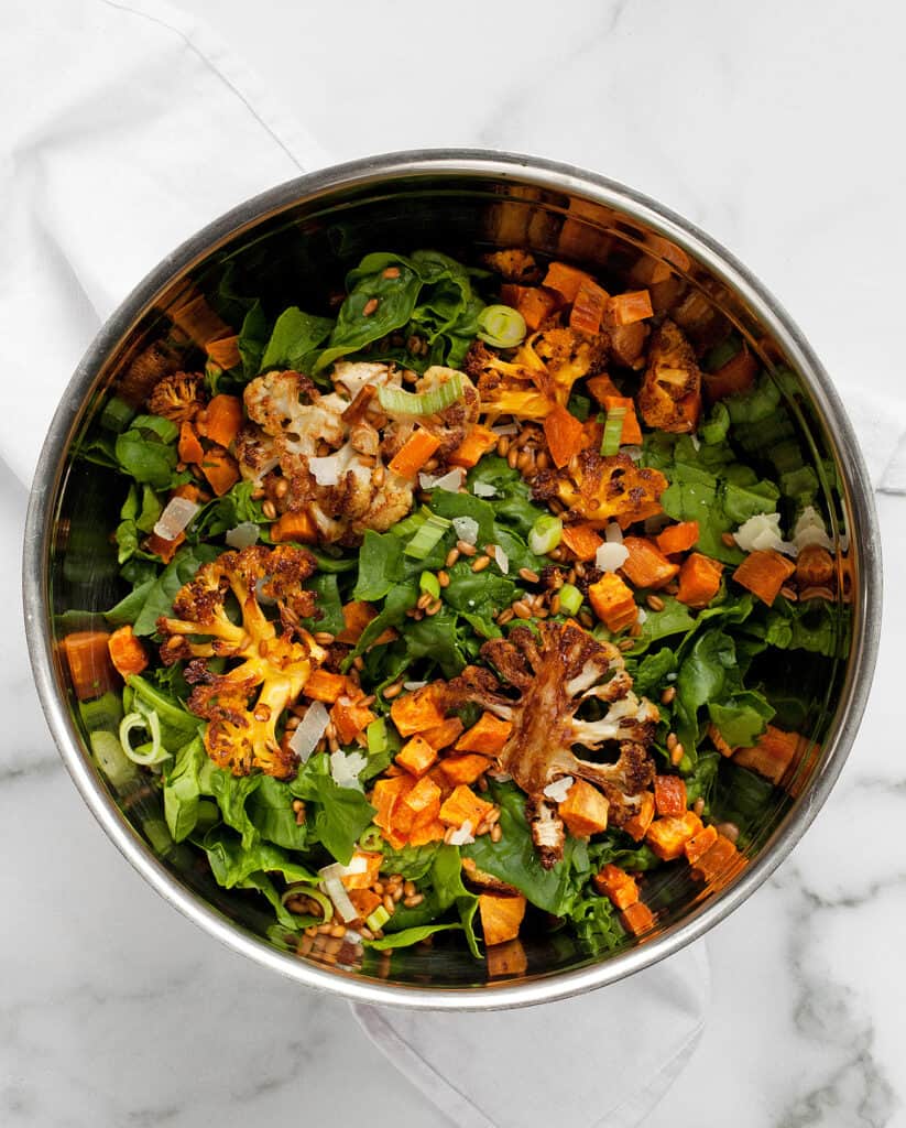 Combine the spinach and the roasted cauliflower and sweet potatoes in a bowl