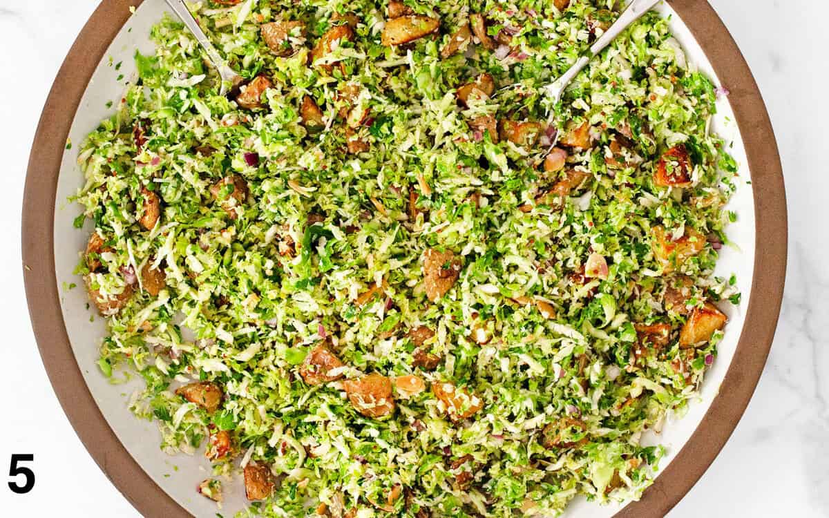 Salad tossed with vinaigrette in a big serving bowl.