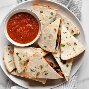 Sweet potato black bean quesadillas cut into triangles on a plate.