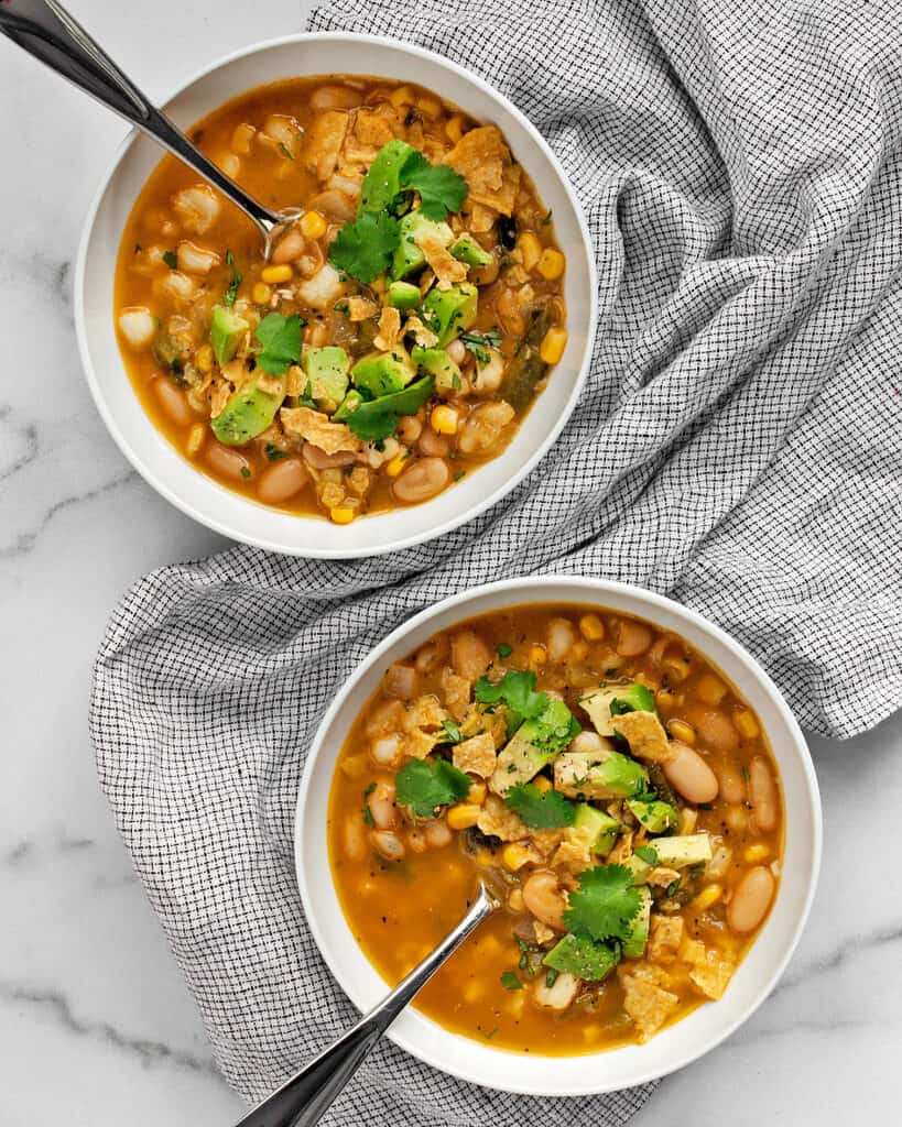 Vegan poblano white bean chili topped with diced avocado