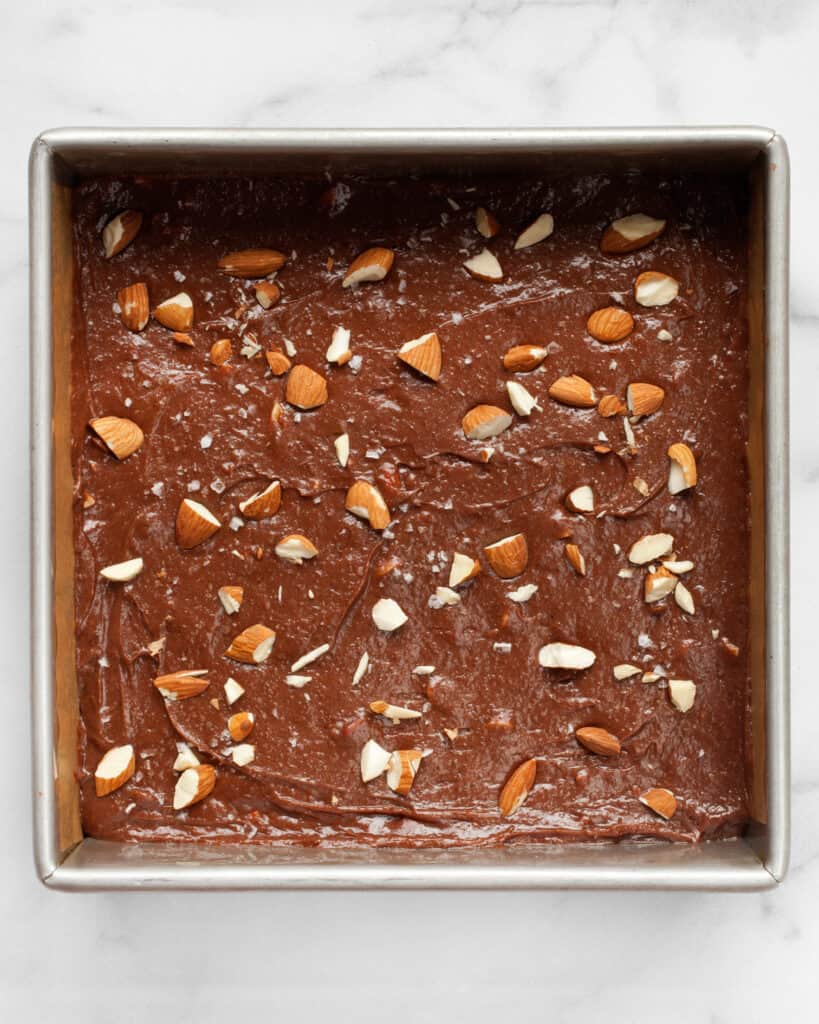 Spread the brownie batter in the pan and sprinkle with almonds