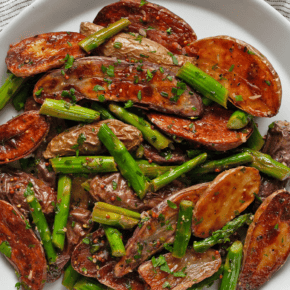 Roasted potato salad with asparagus on a plate.