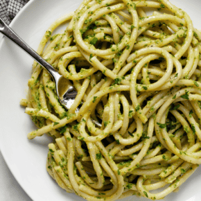 Vegan avocado pasta on a plate with a fork.