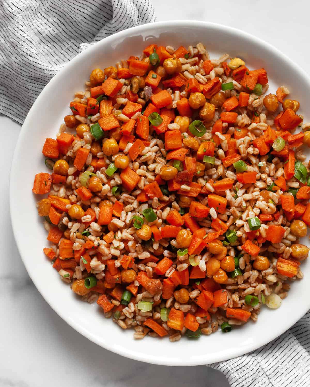 Roasted carrot and chickpea farro on a plate.