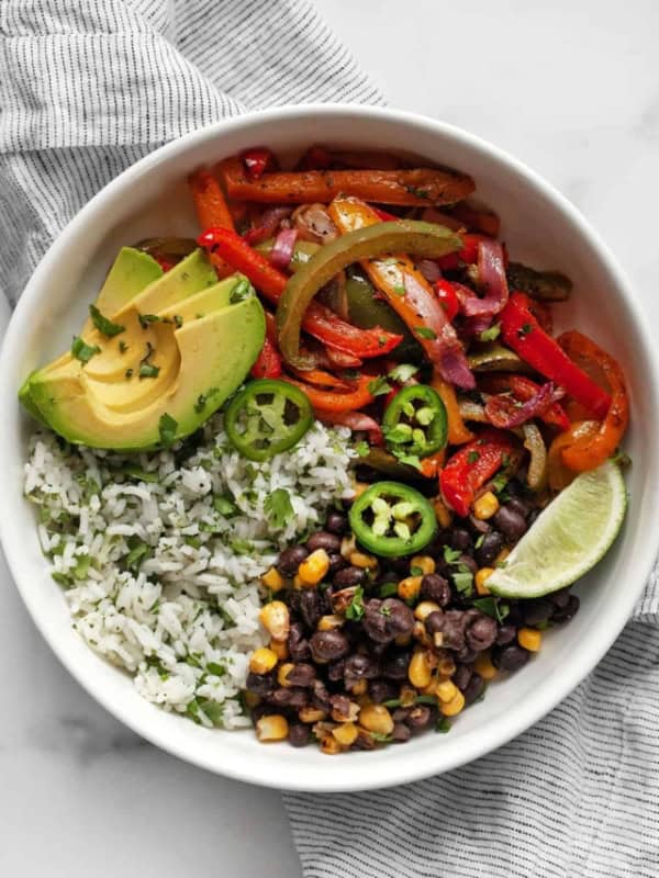 Veggie fajita bowl with roasted peppers and onions and cilantro lime rice.