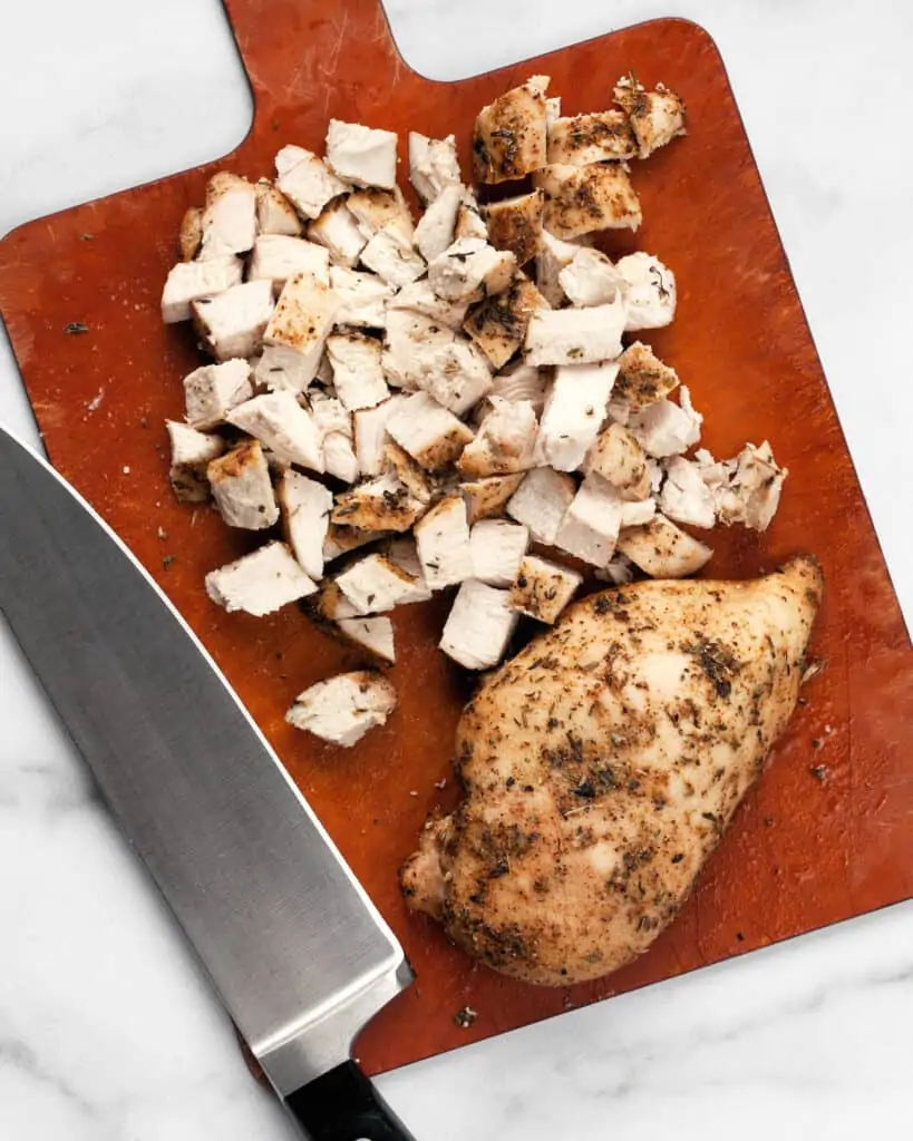 Chopping roasted chicken on a cutting board