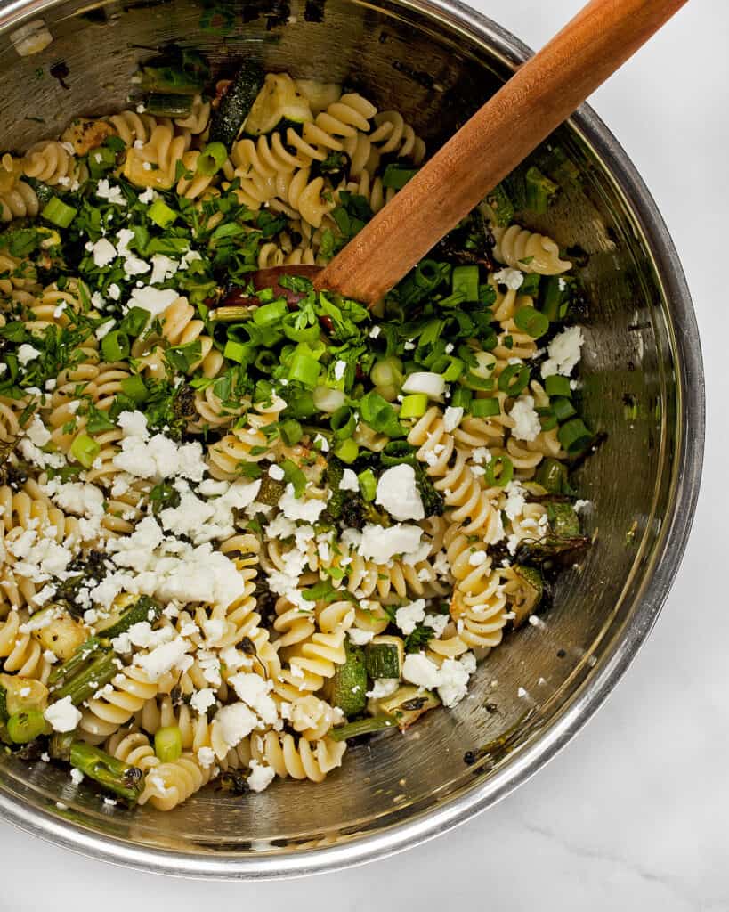 Stir together the pasta, roasted zucchini and broccolini and feta in a bowl