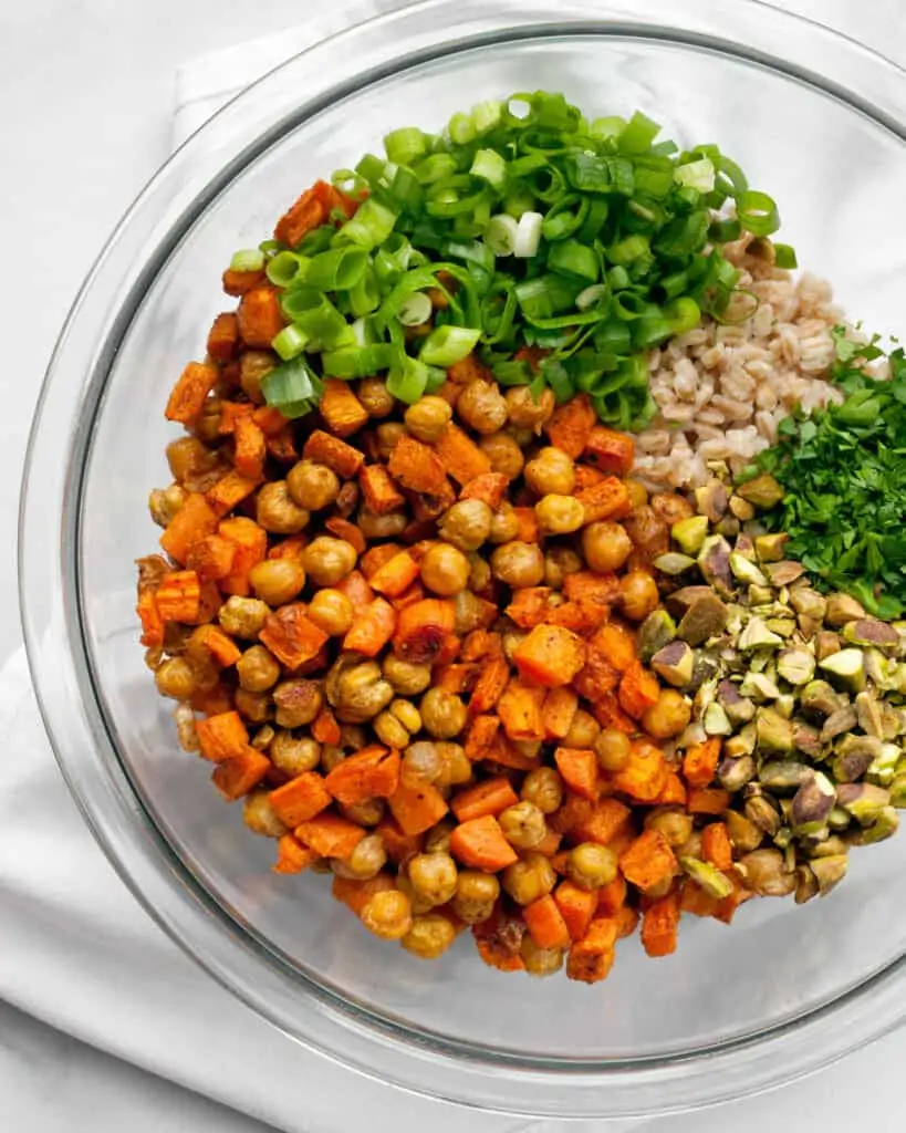 Roasted carrots and chickpea in a bowl with farro, scallions and pistachios