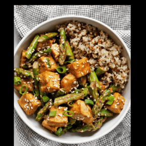 Sesame asparagus tofu with quinoa in a bowl.