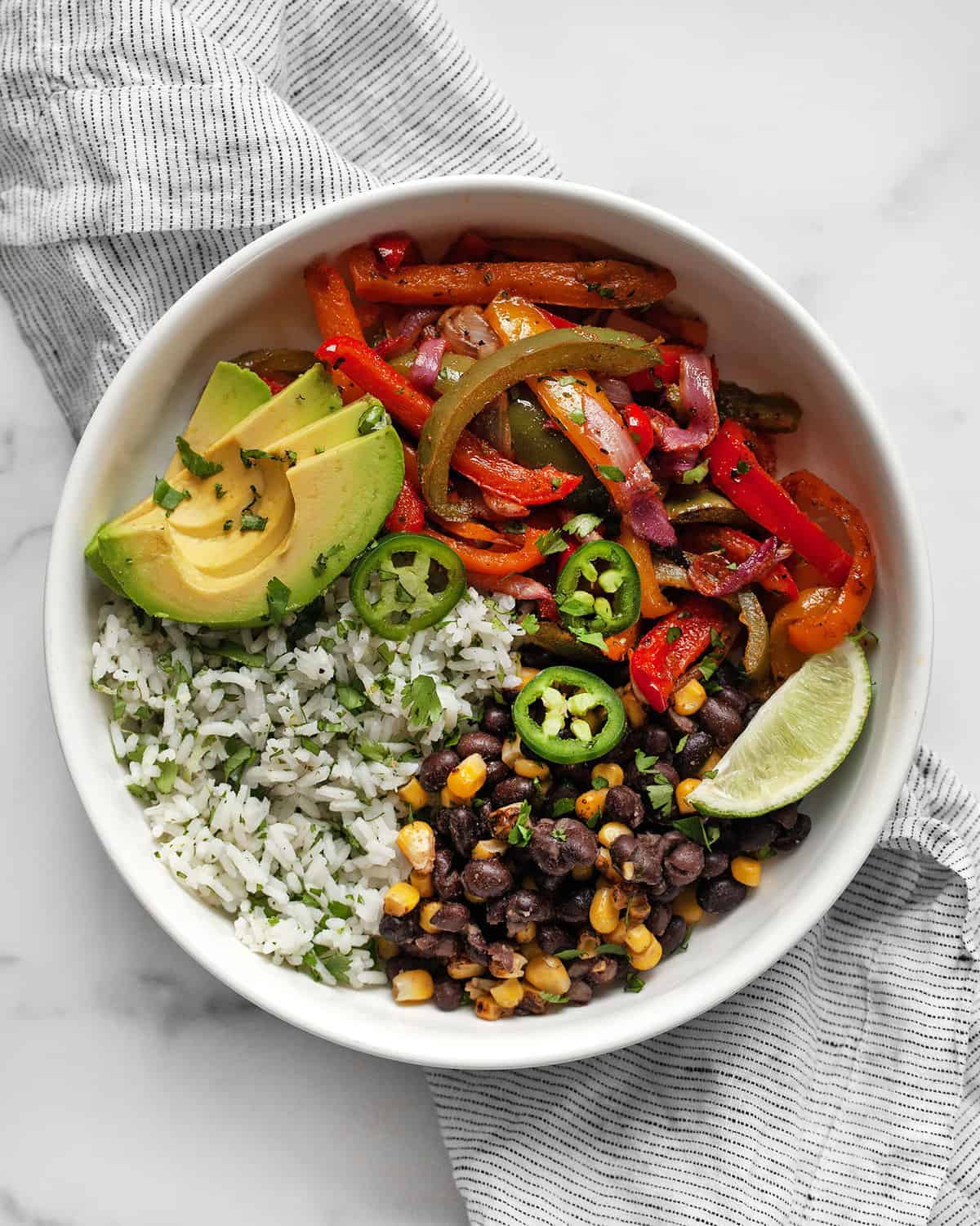 Veggie fajita bowl with roasted peppers and onions and cilantro lime rice.