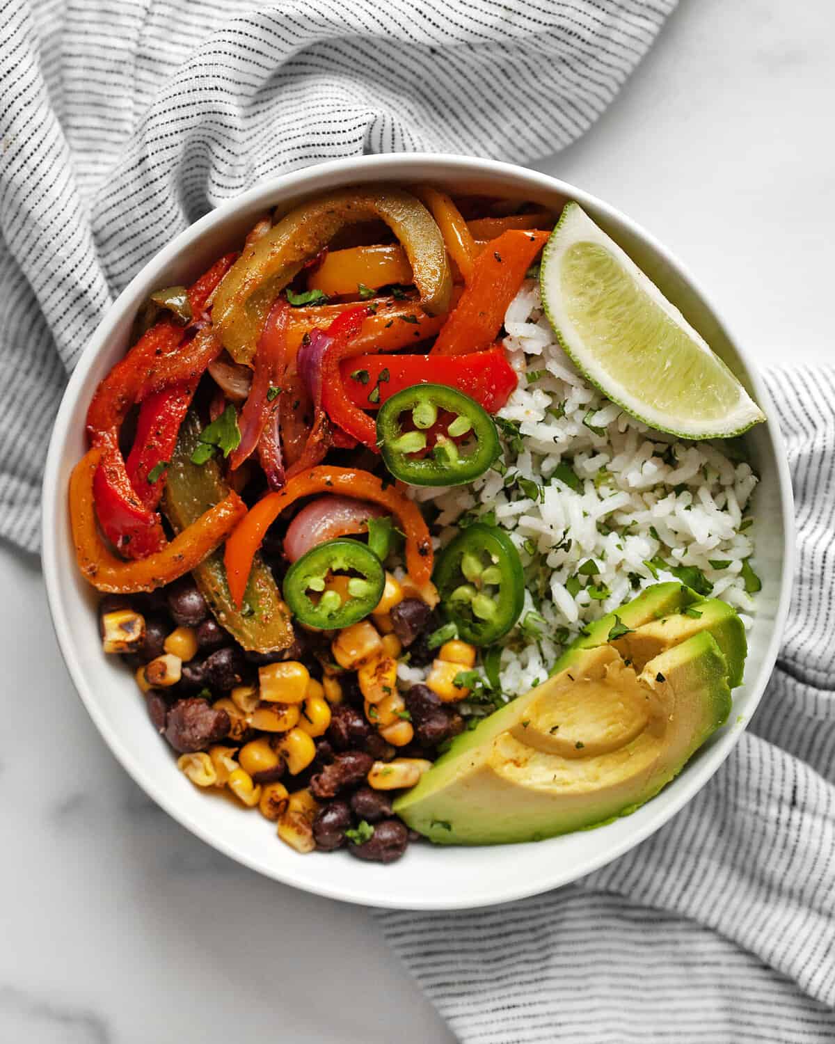 Veggie fajita bowl with roasted peppers and onions and cilantro lime rice.