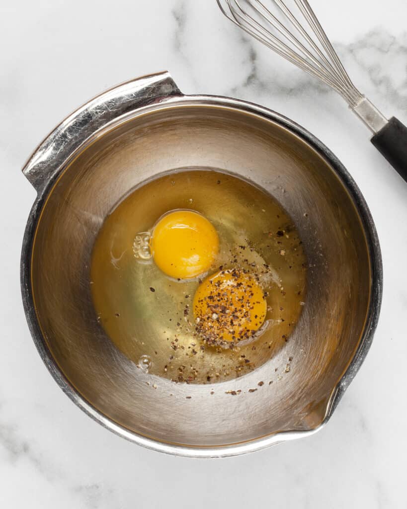 Eggs in bowl with salt and pepper 