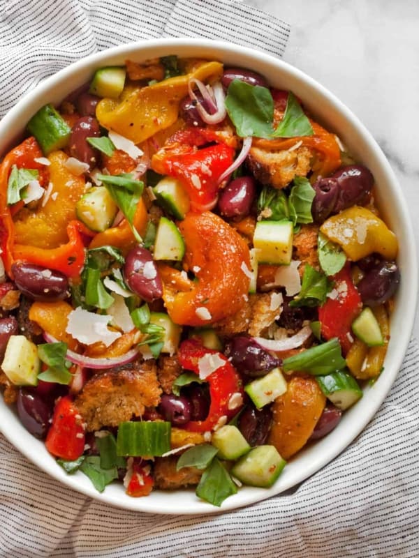 Salad with roasted peppers, cucumbers and olives in a bowl