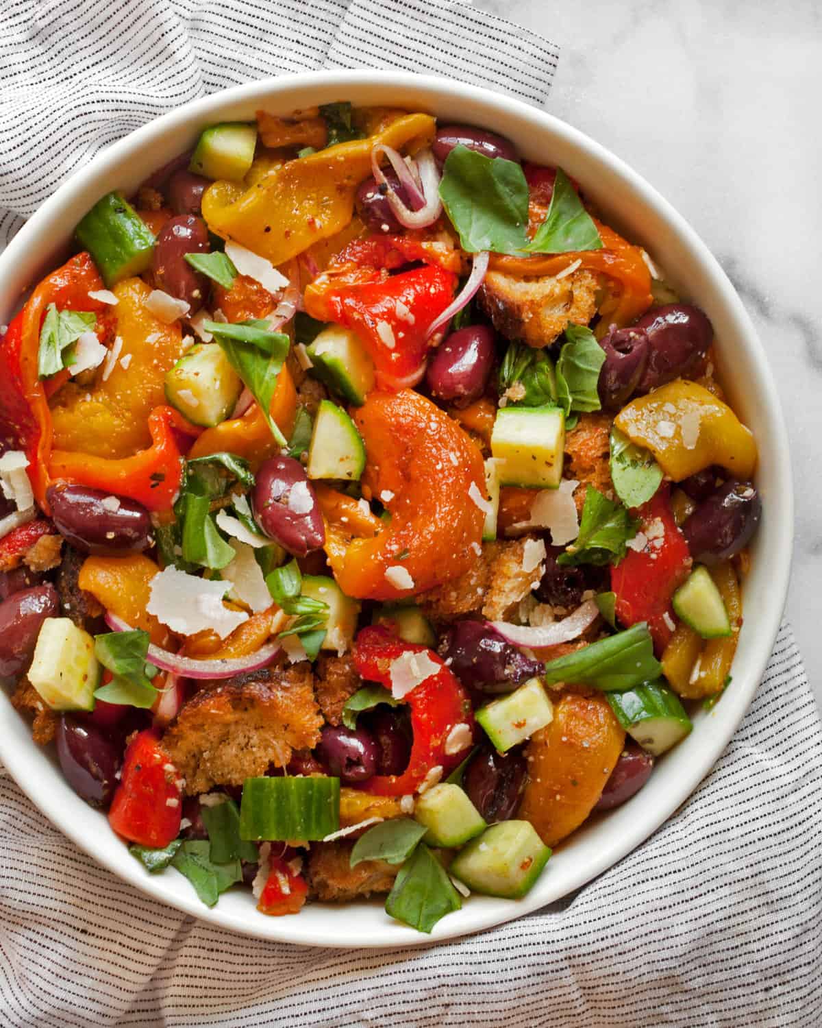 Salad with roasted peppers, cucumbers and olives in a bowl