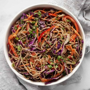 Salad with soba noodles, cabbage, carrots and bell peppers in a bowl.
