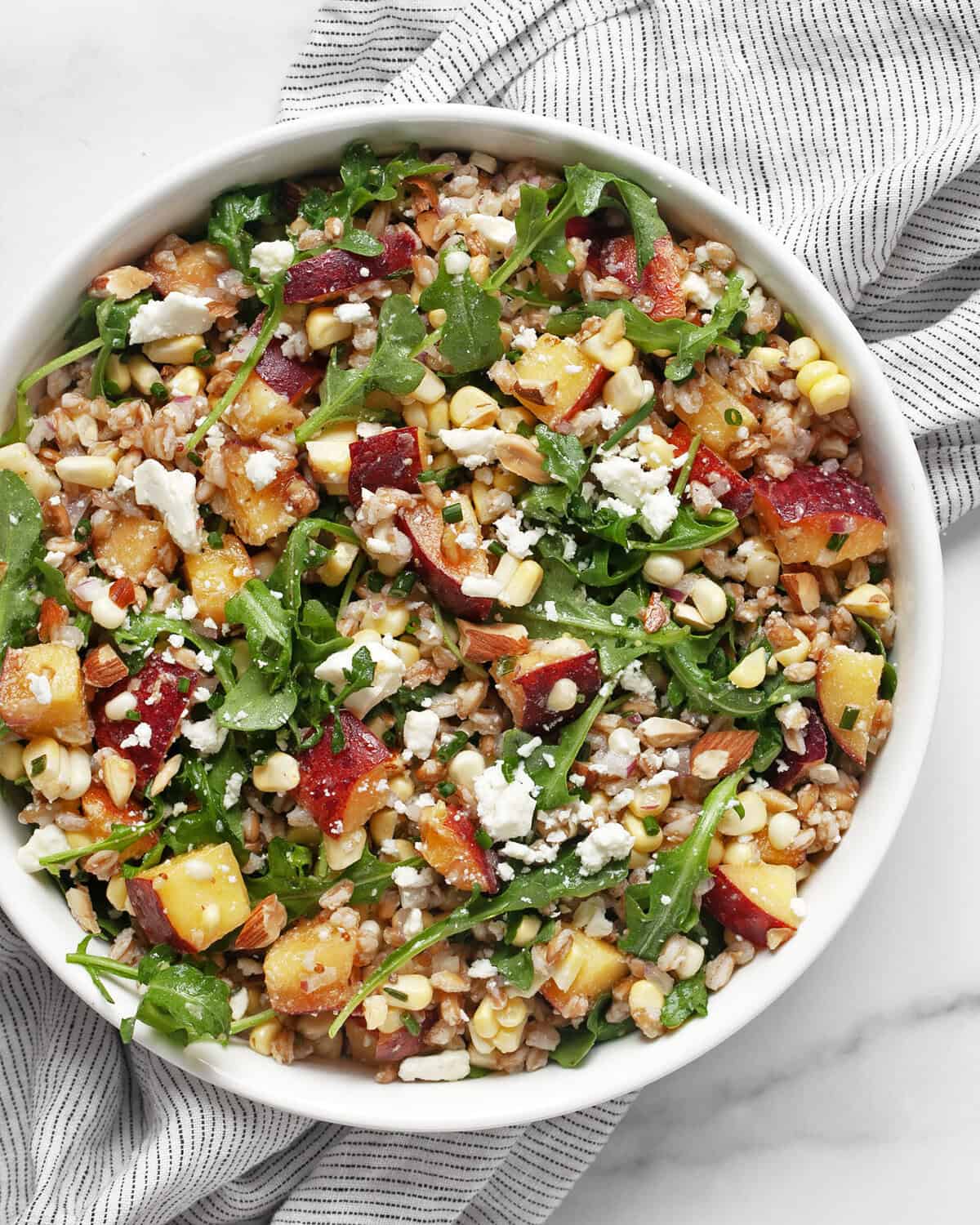 Peach corn farro salad in a bowl.