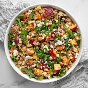 Peach corn farro salad in a bowl.
