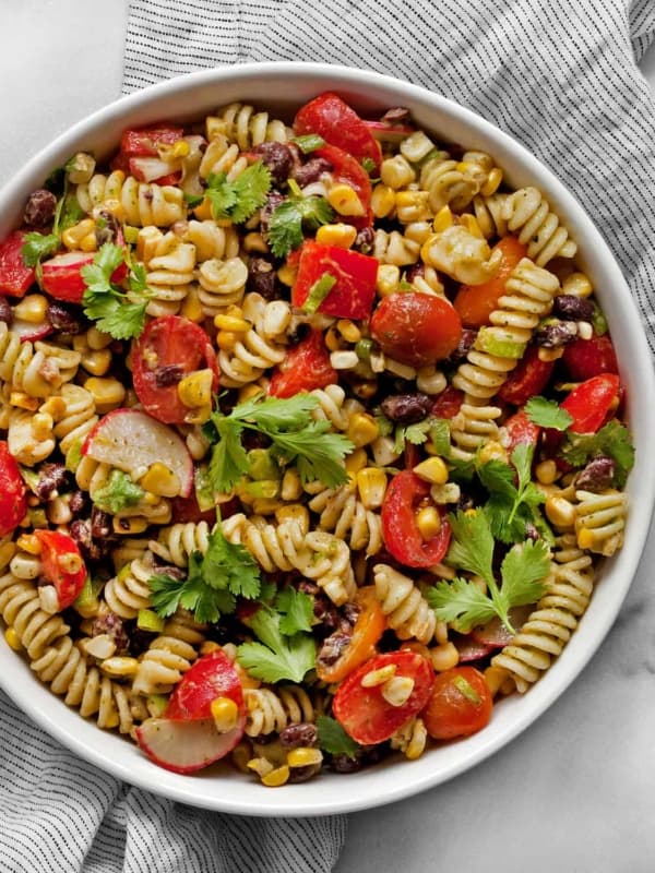 Southwest pasta salad with grilled corn, black beans and radishes in a bowl.
