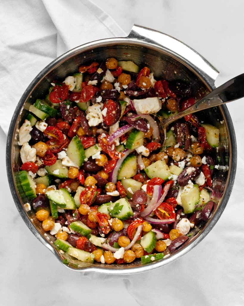 Stirring together Greek salad ingredients