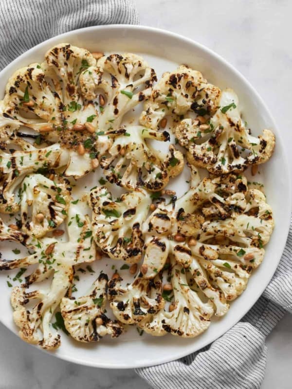 Grilled cauliflower steaks on a plate.