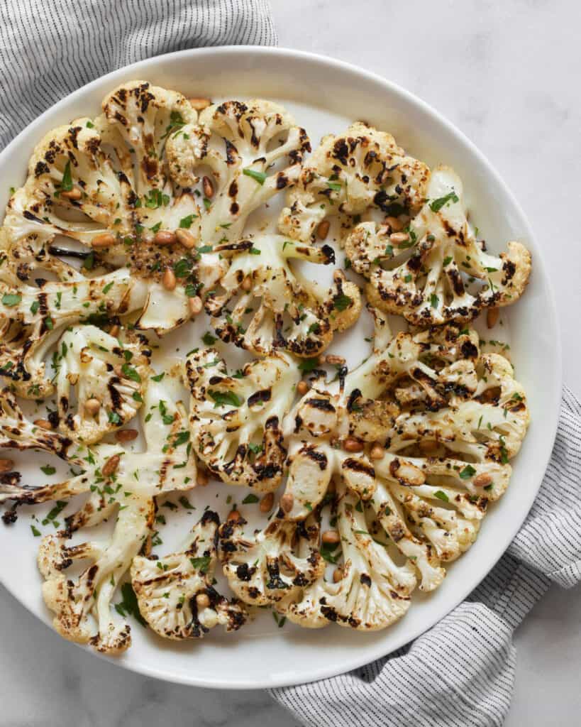 Grilled cauliflower steaks on a plate.