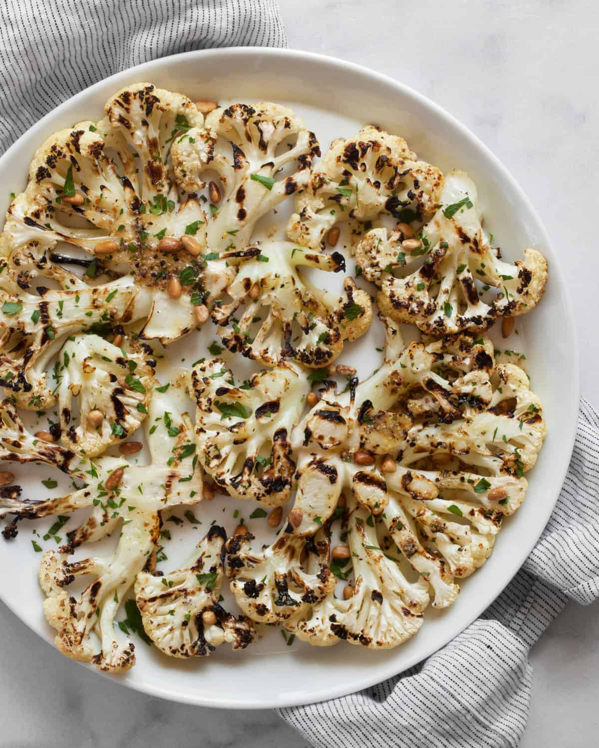 Grilled cauliflower steaks on a plate.