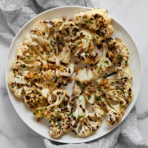 Grilled cauliflower steaks on a plate.