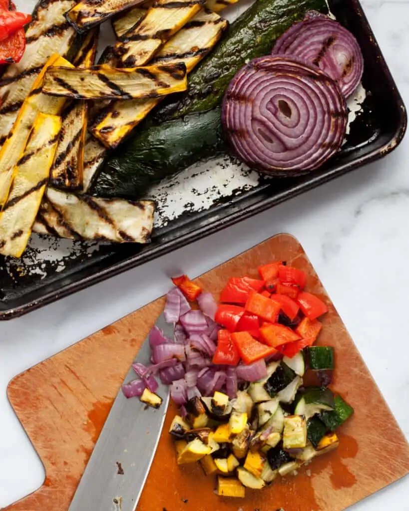 Dicing grilled vegetables on a cutting board