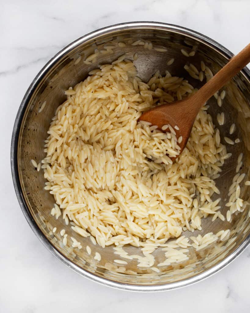 Stirring orzo into vinaigrette