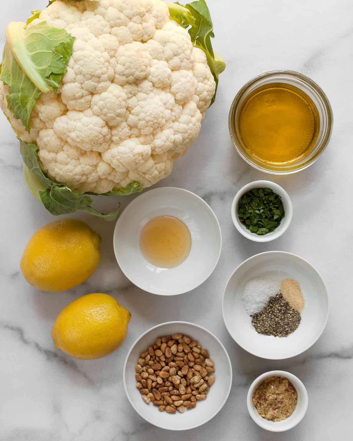 Ingredients including cauliflower, olive oil, honey, mustard, spices, lemon and parsley.