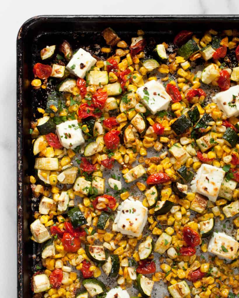 Baked feta, zucchini, corn & tomatoes on a sheet pan