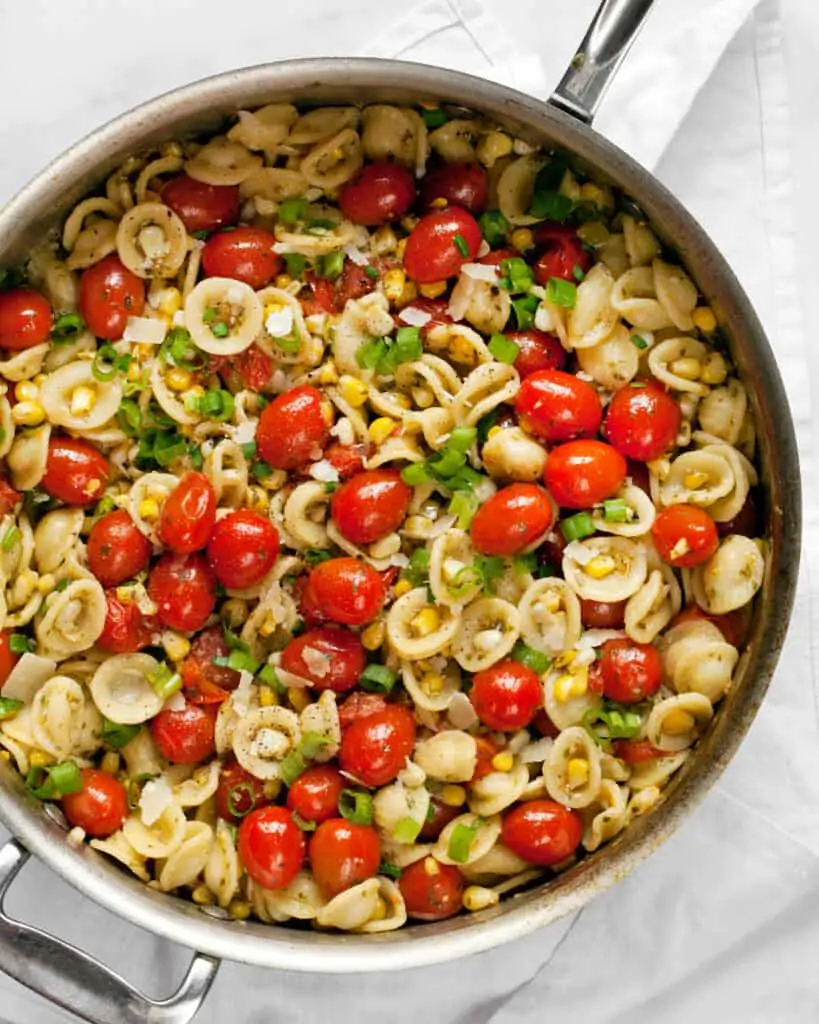 Orecchiette pasta with corn and tomatoes in a skillet