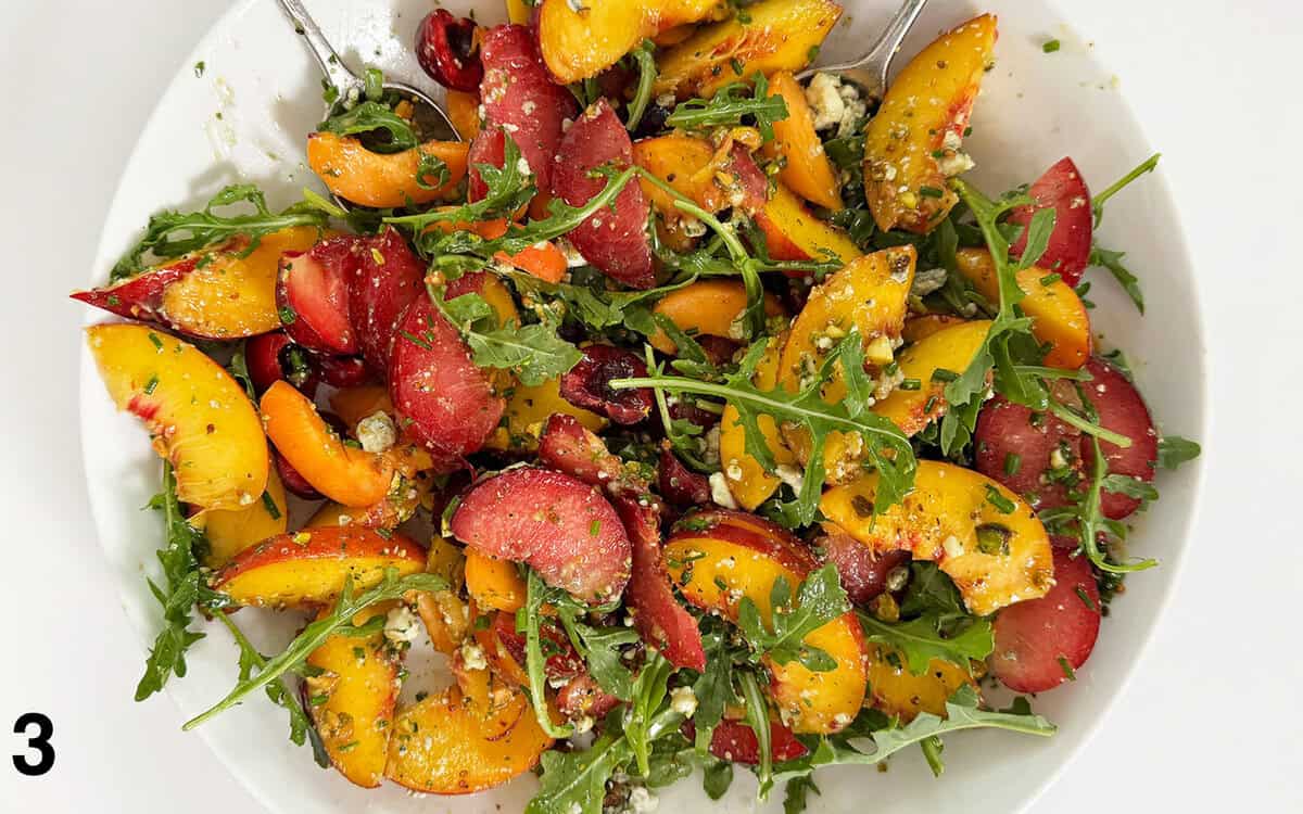 Salad tossed with dressing in a large bowl.