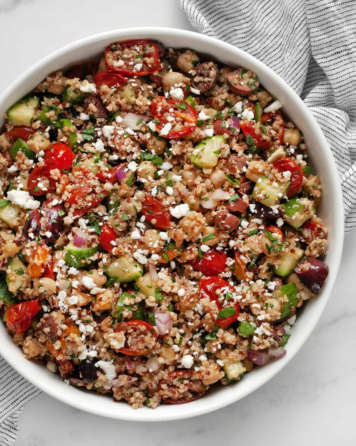 Serving bowl with roasted tomato, chickpea quinoa salad.