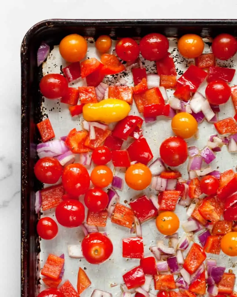 Cherry tomatoes, peppers and onions on a sheet pan