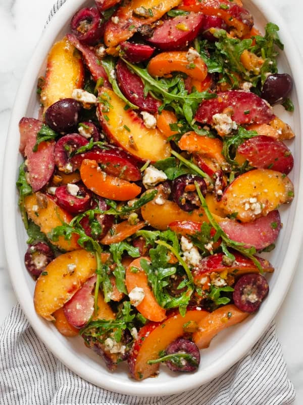 Stone fruit salad on an oval-shaped serving plate.