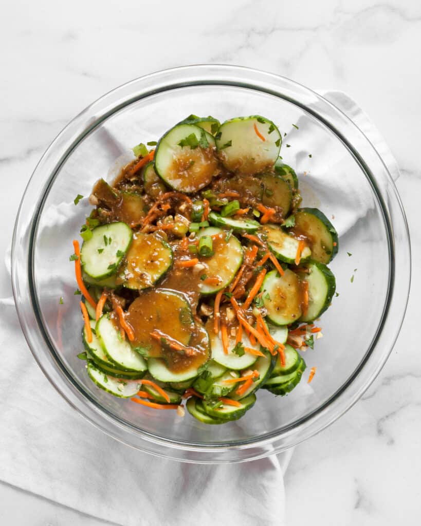 Stirring peanut vinaigrette into cucumber salad