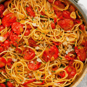 Burst cherry tomato pasta in a skillet.