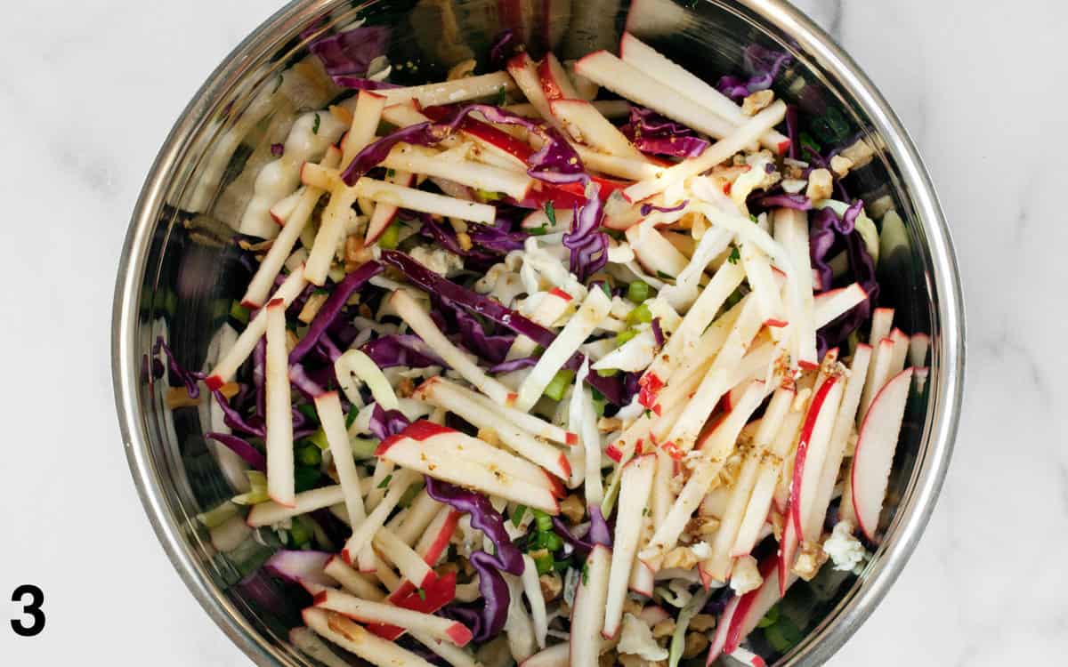 Salad tossed with vinaigrette in a bowl.