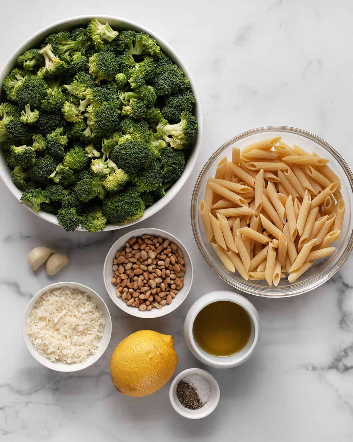 Ingredients including broccoli, penne, pine nuts, parmesan, olive oil, lemon, garlic, salt and pepper.