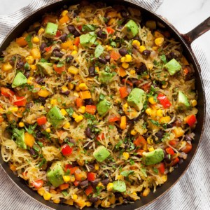 Spaghetti squash with beans, corn and peppers in a skillet.