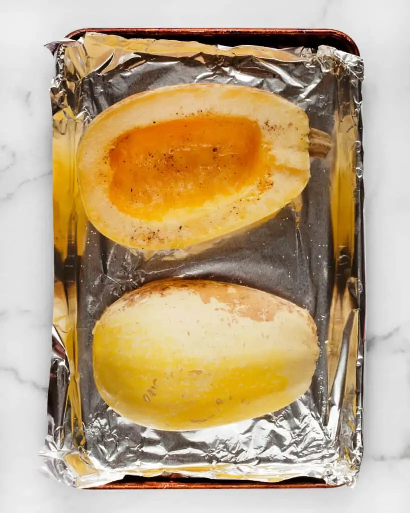 A halved roasted spaghetti squash ona sheet pan