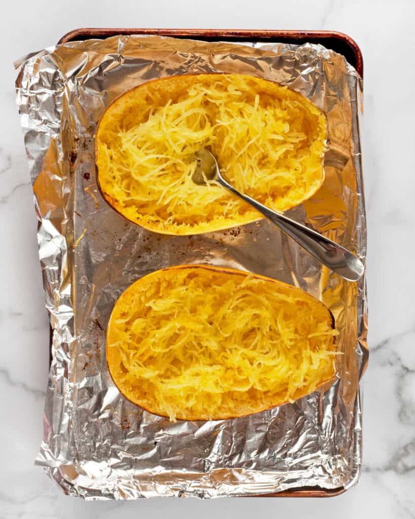 Combing out the flesh of a spaghetti squash with a fork