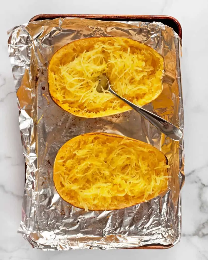 Combing out the flesh of a spaghetti squash with a fork