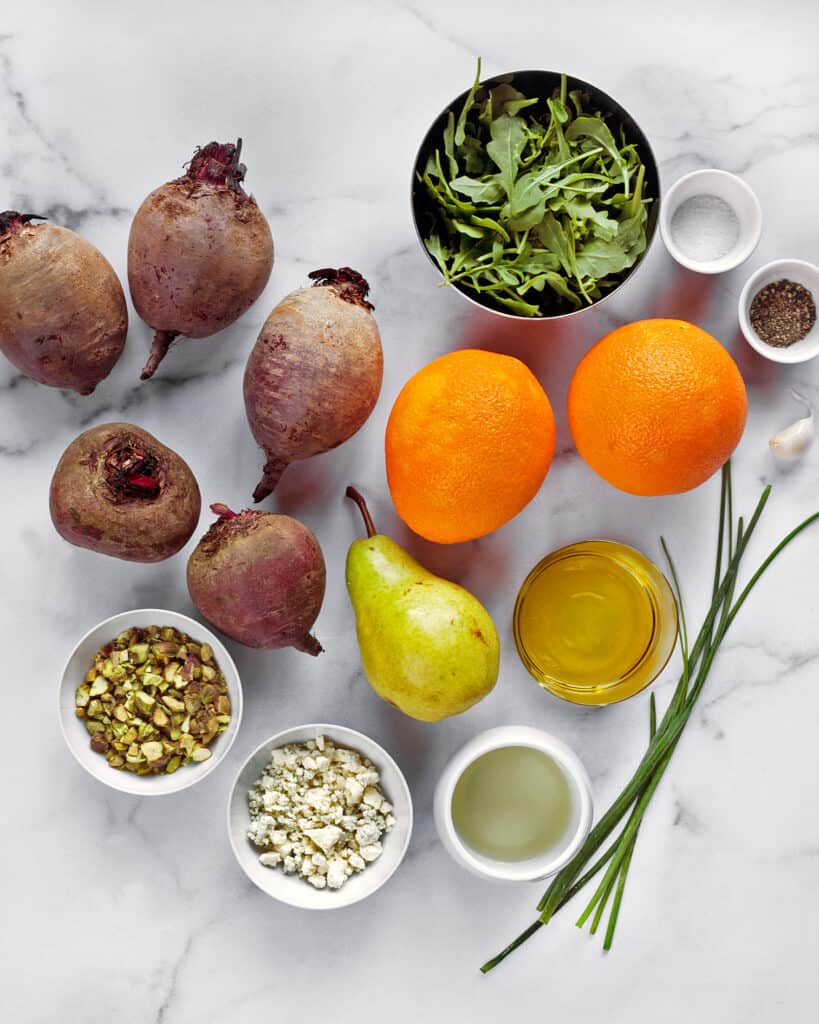 Ingredients for roasted beet salad including beets, oranges, pears, pistachios, blue cheese and chives