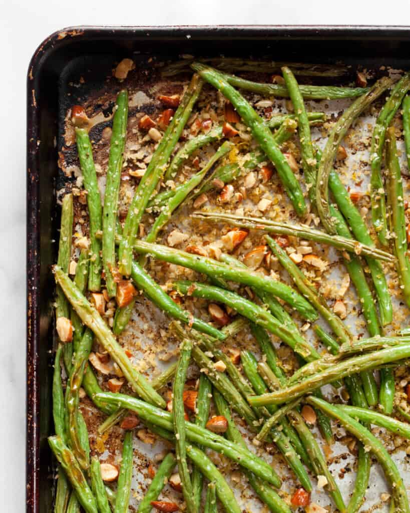 Roasted green beans on sheet pan tossed in almond breadcrumbs