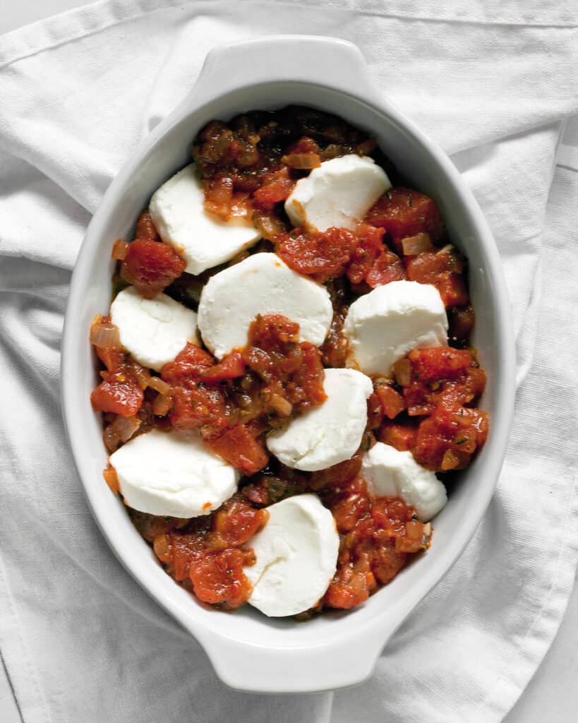 Arrange the goat cheese and tomatoes in the baking dish