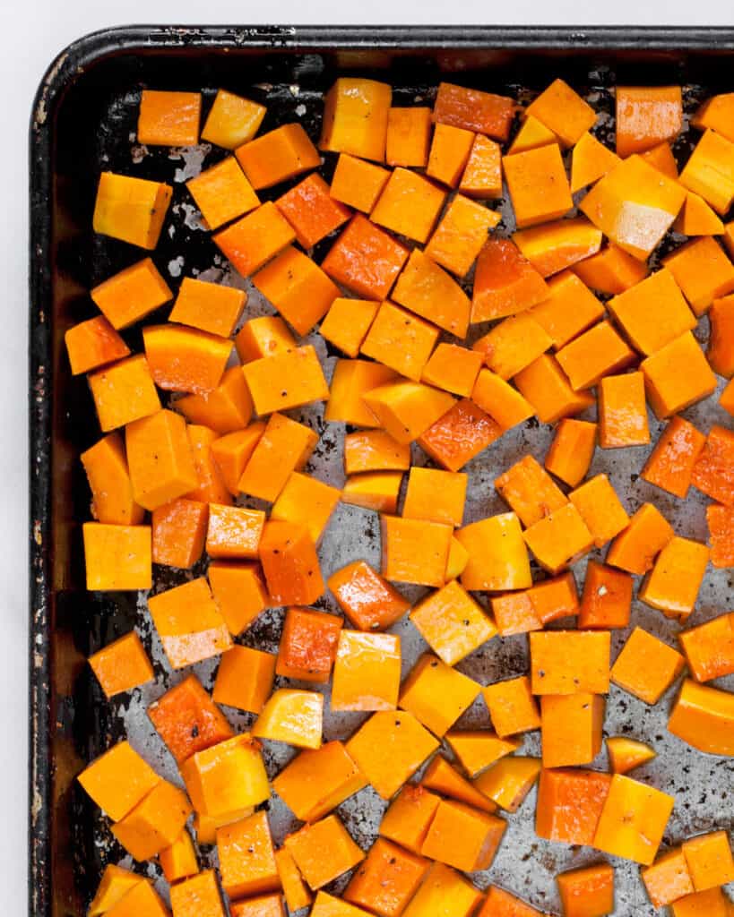 Diced butternut squash on a sheet pan