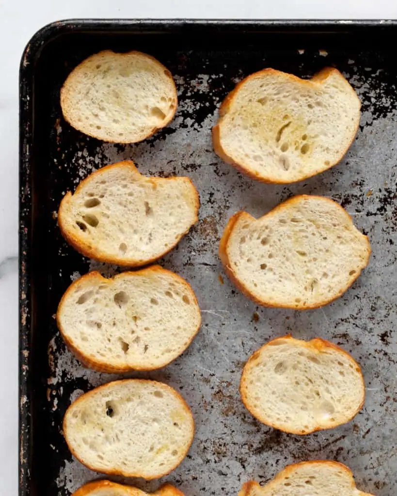 Toasted baguette slices on a sheet pan